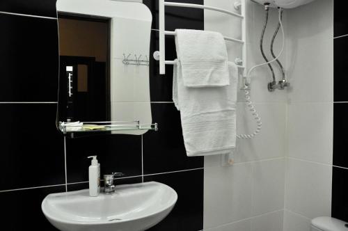 bagno con lavandino, specchio e asciugamani di Skarbek's a Lviv