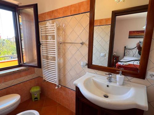 a bathroom with a sink and a mirror and a toilet at Residenza Sole e Luna Capo Vaticano in Ricadi