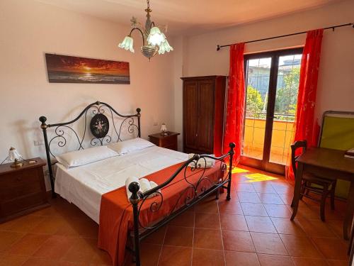 a bedroom with a bed and a table and a window at Residenza Sole e Luna Capo Vaticano in Ricadi