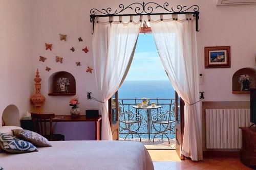 a bedroom with a bed and a view of the ocean at La dimora degli Dei in Praiano