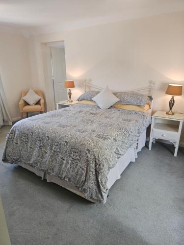 a bedroom with a bed and two tables and two lamps at The Martins B&B in Chelsworth