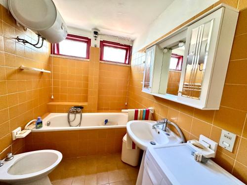 a bathroom with a sink and a tub and a toilet at Trilocale A2 in Marina di Bibbona