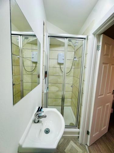 a bathroom with a sink and a shower at Melrose Abbey Guest House in Liverpool