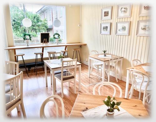a dining room with tables and chairs and a piano at 27ans Nattlogi in Vadstena