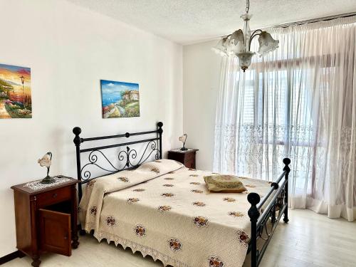 a bedroom with a bed and a large window at Trilocale A2 in Marina di Bibbona
