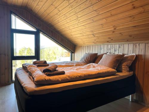 a large bed in a room with a wooden ceiling at Stryn Nature Lodge in Stryn