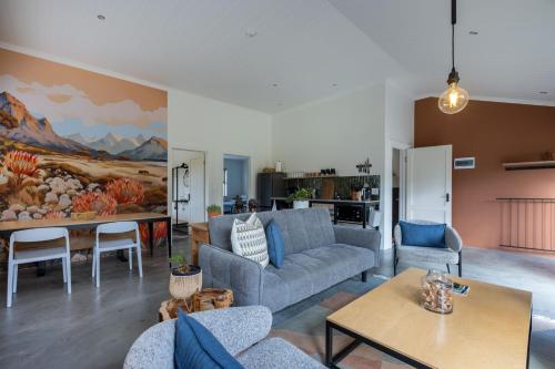 a living room with a couch and a table at Cape Dutch Stay, Suite A in Sedgefield