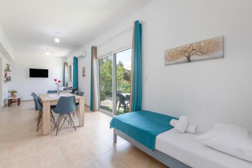 a bedroom with a bed and a dining room with a table at Stella's Olive Tree House in Adelianos Kampos