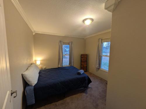 a bedroom with a bed and two windows at 2-bedroom house close to Marathon in Robinson