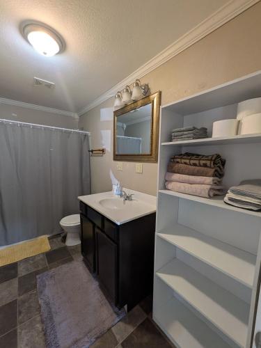 a bathroom with a sink and a toilet and a mirror at 2-bedroom house close to Marathon in Robinson