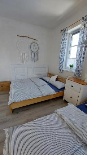 a bedroom with two beds and a clock on the wall at Apartmány LENKA in Mikulášovice