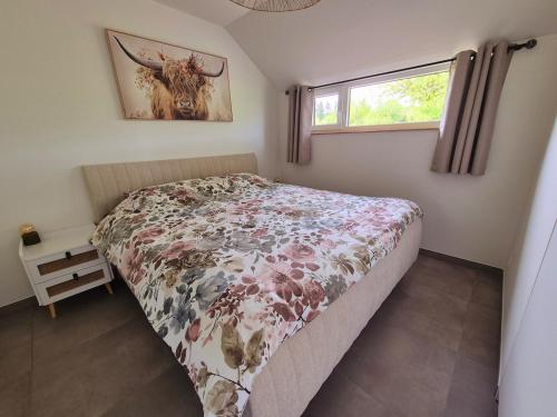 a bedroom with a bed with a cow picture on the wall at Gîte La Petite Villette in Fronville