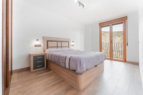 ein Schlafzimmer mit einem großen Bett und einem Fenster in der Unterkunft El Tranco Apartamentos in Villel