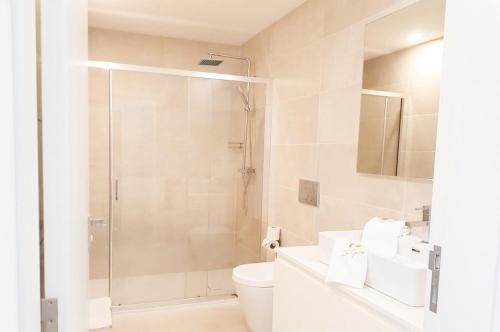 a white bathroom with a shower and a toilet at ERMAL HOUSE in Braga
