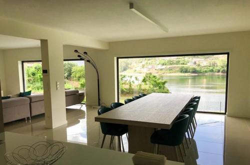 a dining room with a table and chairs and a large window at ERMAL HOUSE in Braga
