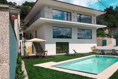 a house with a swimming pool in front of it at ERMAL HOUSE in Braga