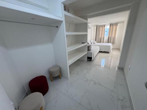 a white room with a bedroom with a bed and a couch at Mirante Piratininga - Casa 2 quartos - Vista Panorâmica Lagoa e Praia in Niterói