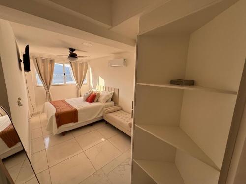 a small bedroom with a bed and a window at Mirante Piratininga - Casa 2 quartos - Vista Panorâmica Lagoa e Praia in Niterói
