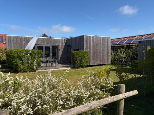a wooden house with a garden in front of it at Anpektop - Ecohuisjes Terschelling in Midsland