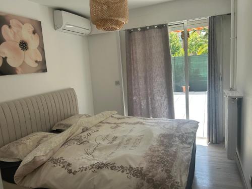 a bedroom with a bed and a window at L'échappée Méditerrannée in Vallauris