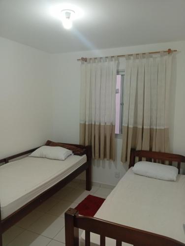 two beds in a room with a window at SP , Interlagos,Expo Transamérica, 3 Hosp in São Paulo