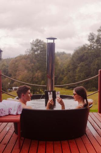 a man and woman sitting in a hot tub on a deck at Aslan Haus in Villarrica