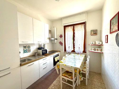 a kitchen with a table and a kitchen with white cabinets at Francesca Appartamento con giardino in Levanto