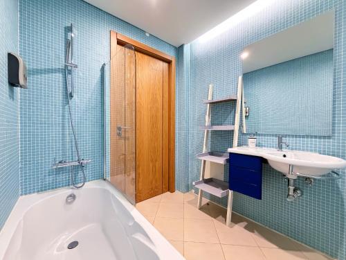 a bathroom with a tub and a sink at Tavira Escape with Pool by BeCherish in Tavira