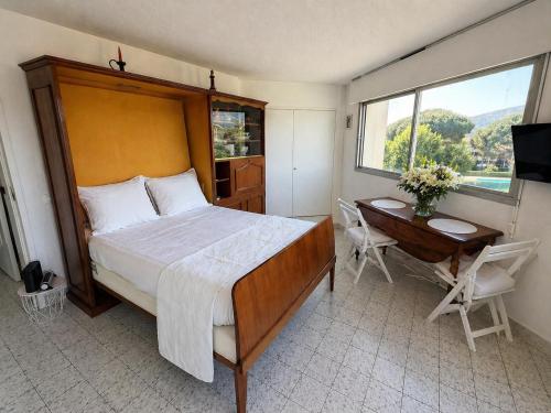 a bedroom with a bed and a desk and a window at Azur Couple Studio in Mandelieu-La Napoule