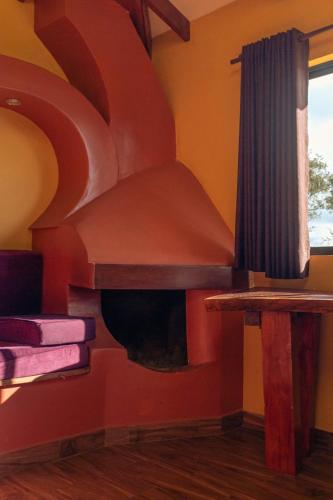 a living room with a fire place in the wall at Cabaña Los Guapurús in Samaipata