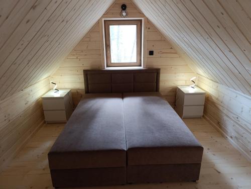 a bedroom with a large bed in a attic at Sosnowy Oddech in Samsonów