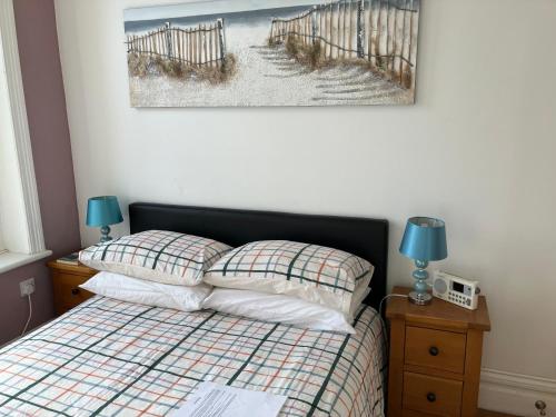 a bedroom with a bed and a picture of a beach at High Street Suites 3 in Ventnor