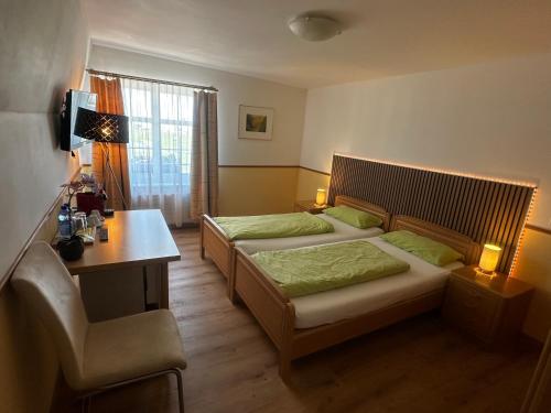 a hotel room with two beds and a desk and a desk at Gasthaus Ochsen in Tägerwilen