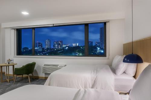ein Schlafzimmer mit Fenster und Stadtblick in der Unterkunft Best Western Plus Hotel Terraza in San Salvador
