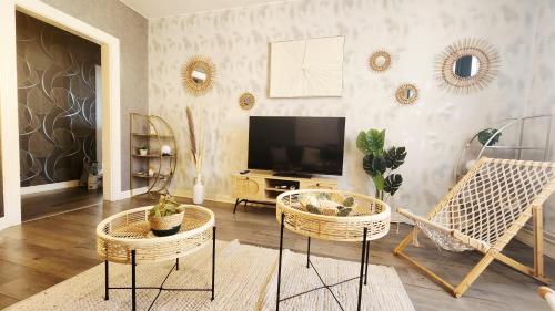 a living room with two chairs and a flat screen tv at Refuge des Rêves in Amnéville