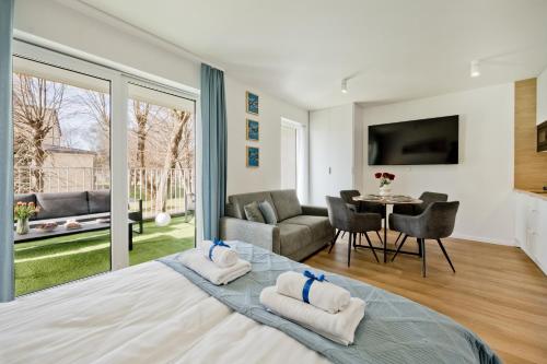 a bedroom with a large bed and a living room at Casa Baia BlueApart Hel in Hel