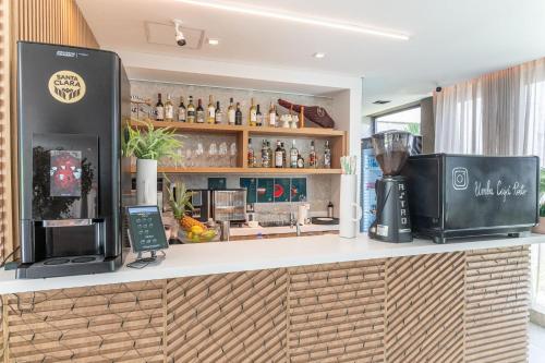 a kitchen with a counter with a coffee shop at Beach Class Summer resort condominium by Carpediem in Porto De Galinhas