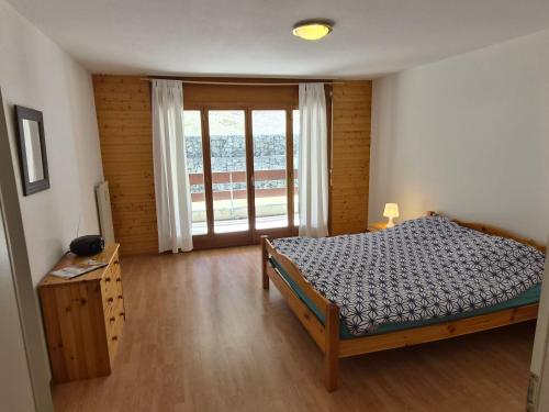 a bedroom with a bed and a large window at Torgon in Torgon