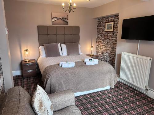 a bedroom with a bed with two towels on it at The Westbourne Guest House in Llandudno