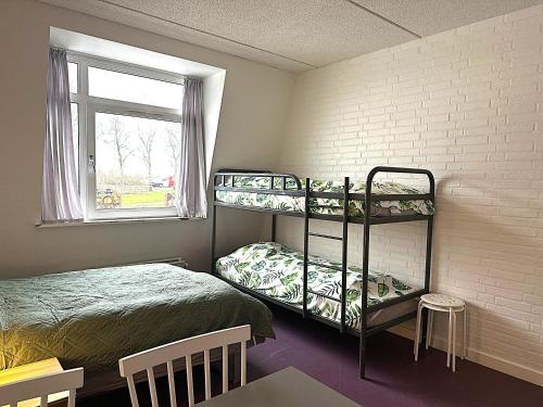 a bedroom with two bunk beds and a window at Oasen Samsø in Nordby
