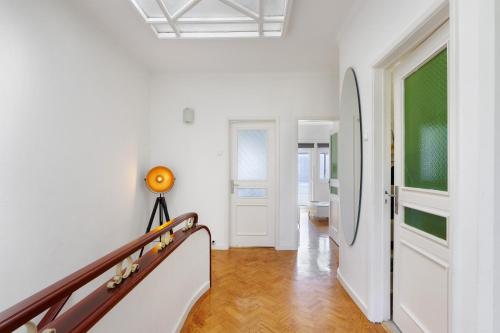 a hallway with white walls and wooden floors and a staircase at Azuaga House Sunny Charming Apt in Vila Nova de Gaia