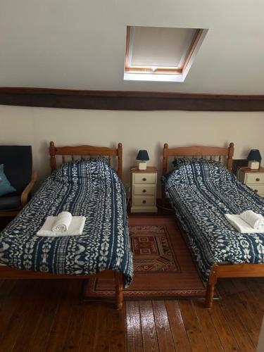 two beds sitting next to each other in a bedroom at Le Chene Vert in Millac