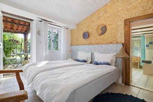 a bedroom with a large bed with a stone wall at Les Orchidées - Chambre in Savignac-de-Miremont