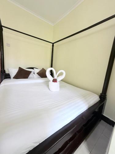 a room with a bed with a bow on it at Cajanus Inn & Safaris in Karatu