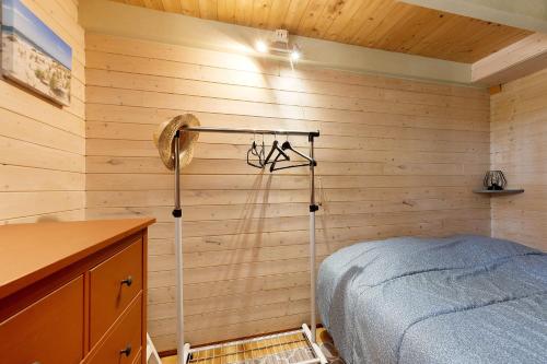 a bedroom with a bed in a wooden wall at Petite Villa Mitoyenne Dans Pinède in Lacanau-Océan