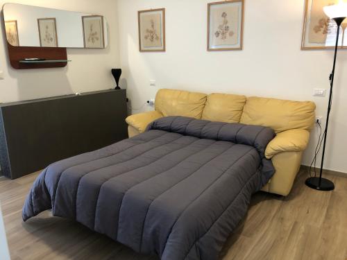 a bed and a couch in a room at La Tana de Il Lupo e La Volpe in Centobuchi