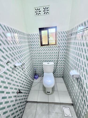 a bathroom with a toilet and a window in it at Cajanus Inn & Safaris in Karatu