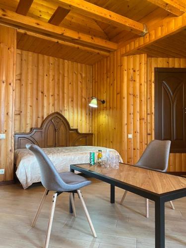 a bedroom with a bed and a table and chairs at Castle Apartments in Schaslyve
