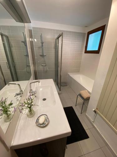 a white bathroom with a sink and a tub at Villa les Jules in Thoard