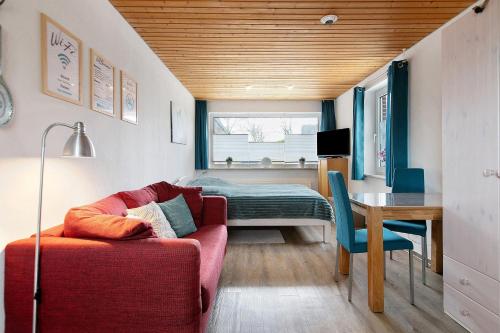 a living room with a couch and a table and a bed at Haus Sonneneck in Oesterdeichstrich